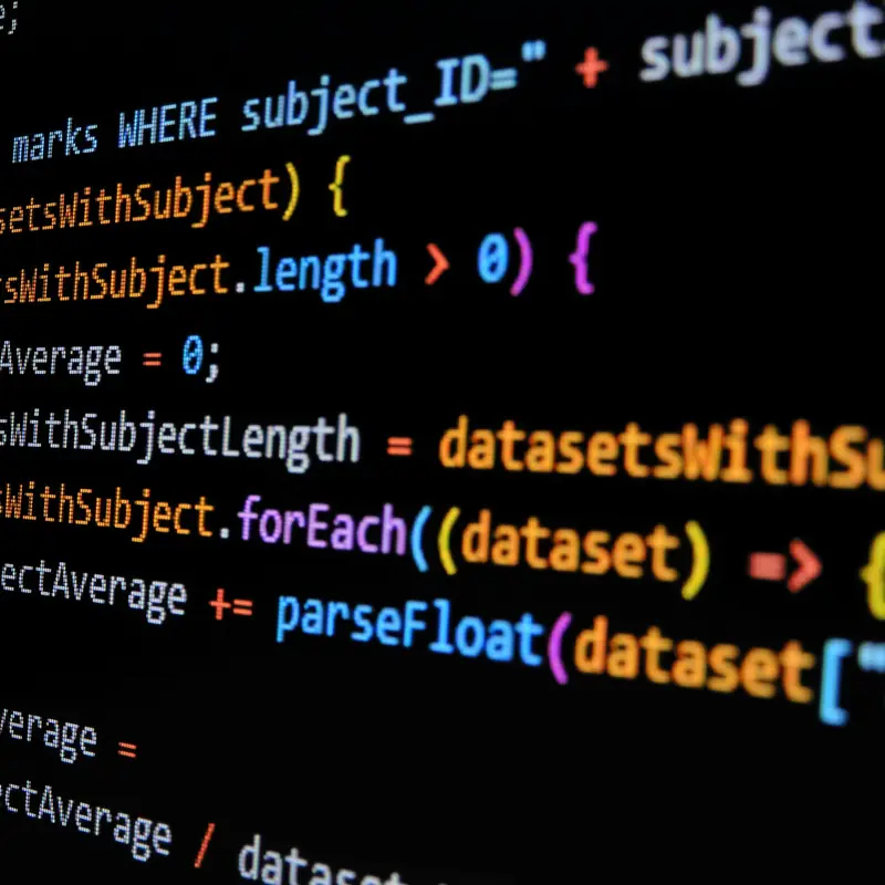 Close-up of colourful JavaScript code on a black screen, seen at an angle